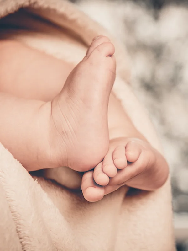 Pieds d'un nouveau-né emmitouflé dans une couverture